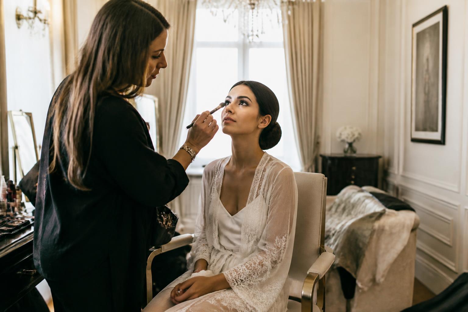 Bride being prepared by a Pro Makeup Artist in a quiet morning suite